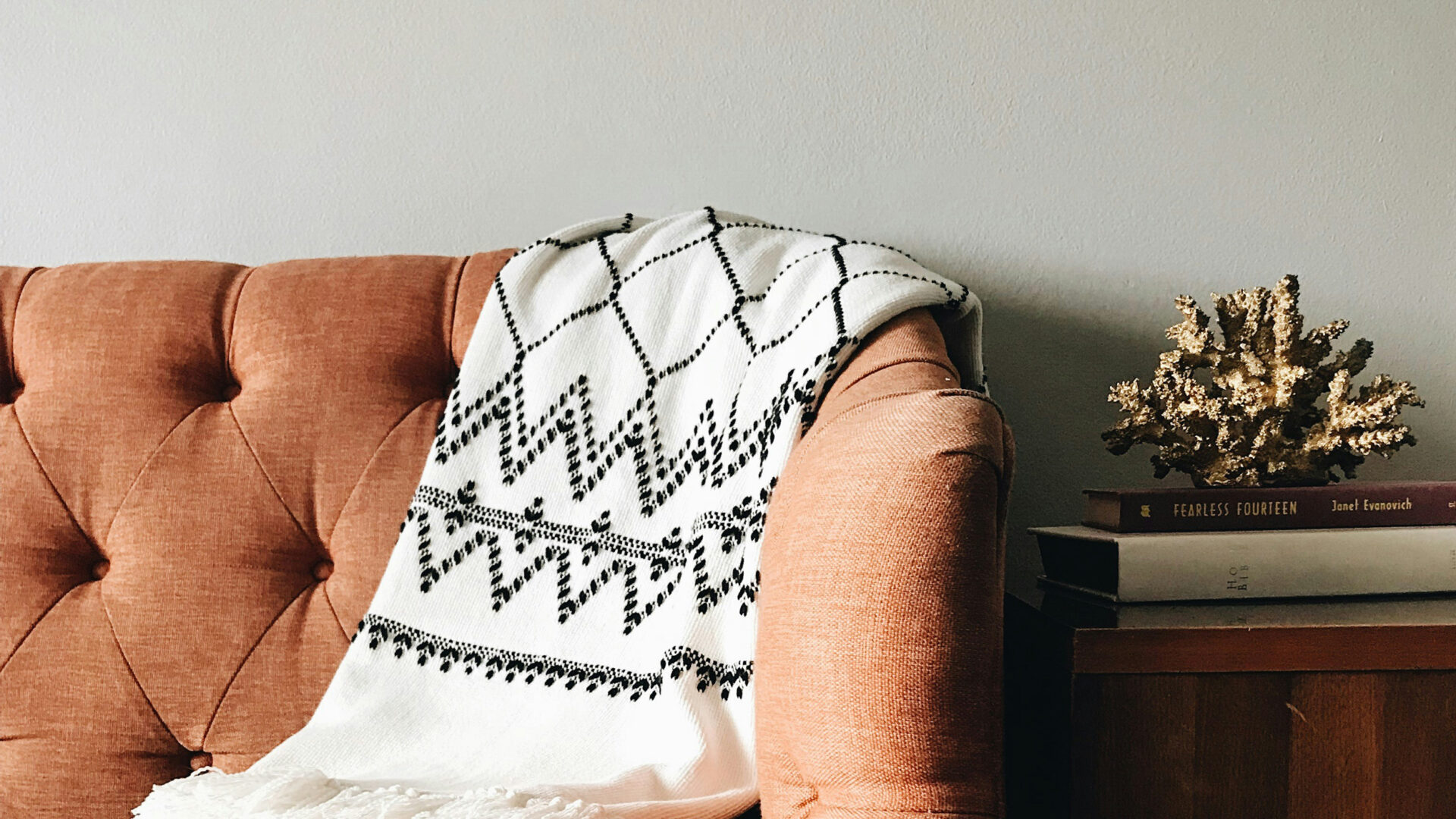 rug draped over orange sofa